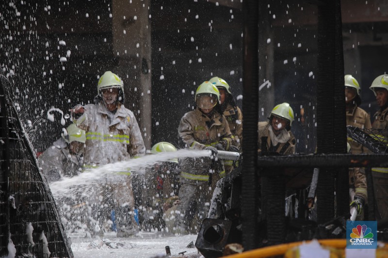 Petugas melakukan pemadaman kebakaran yang melanda Pasar Induk Kramat Jati, Jakarta, Senin (15/12/2025). (CNBC Indonesia/Faisal Rahman)