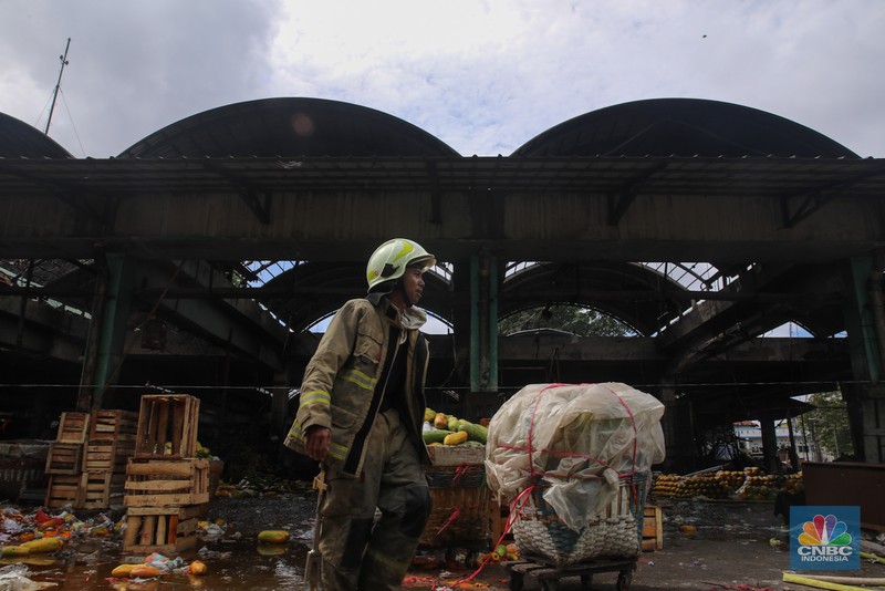 Petugas melakukan pemadaman kebakaran yang melanda Pasar Induk Kramat Jati, Jakarta, Senin (15/12/2025). (CNBC Indonesia/Faisal Rahman)
