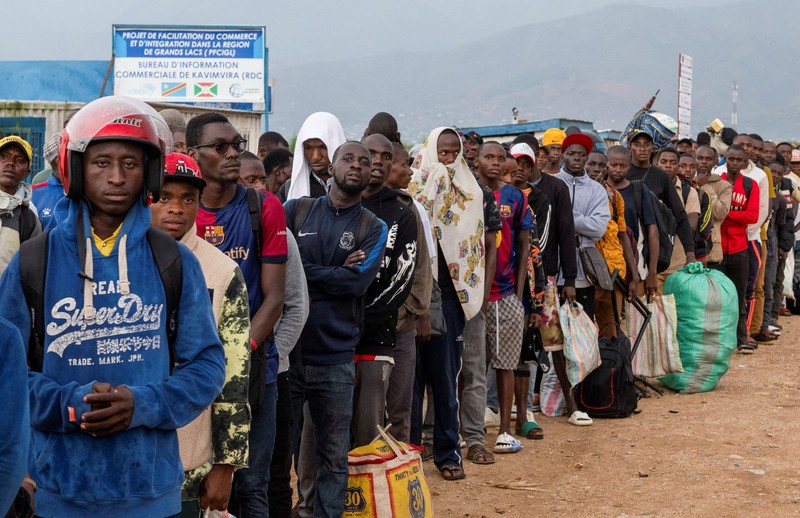 Warga asing yang terjebak selama bentrokan antara anggota Gerakan Aliansi Fleuve Congo AFC-M23 yang merebut kota Uvira dari Angkatan Bersenjata Republik Demokratik Kongo (FARDC), mengantre untuk menyeberangi titik perbatasan di Uvira, di tepi Danau Tanganyika, di provinsi Kivu Selatan, Republik Demokratik Kongo, 14 Desember 2025. (REUTERS/Stringer)