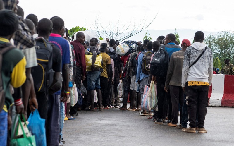 Warga asing yang terjebak selama bentrokan antara anggota Gerakan Aliansi Fleuve Congo AFC-M23 yang merebut kota Uvira dari Angkatan Bersenjata Republik Demokratik Kongo (FARDC), mengantre untuk menyeberangi titik perbatasan di Uvira, di tepi Danau Tanganyika, di provinsi Kivu Selatan, Republik Demokratik Kongo, 14 Desember 2025. (REUTERS/Stringer)