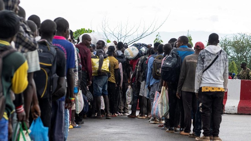Warga asing yang terjebak selama bentrokan antara anggota Gerakan Aliansi Fleuve Congo AFC-M23 yang merebut kota Uvira dari Angkatan Bersenjata Republik Demokratik Kongo (FARDC), mengantre untuk menyeberangi titik perbatasan di Uvira, di tepi Danau Tanganyika, di provinsi Kivu Selatan, Republik Demokratik Kongo, 14 Desember 2025. (REUTERS/Stringer)