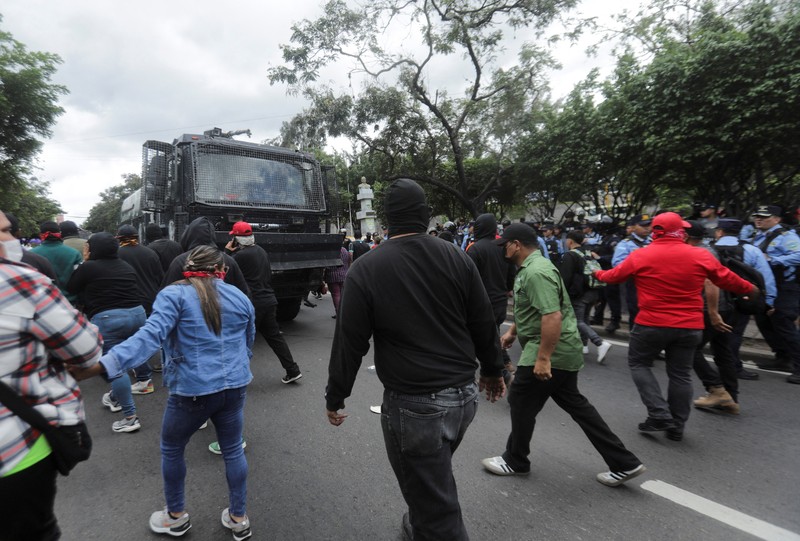 Para pendukung calon presiden Salvador Nasralla dari Partai Liberal berunjuk rasa di depan polisi anti huru hara, lebih dari dua minggu setelah pemilihan presiden, karena penghitungan suara masih terhenti di tengah surat suara yang belum dihitung, tuduhan kecurangan, dan kegagalan sistem pemilu, di Tegucigalpa, Honduras, 15 Desember 2025. (REUTERS/Fredy Rodriguez)