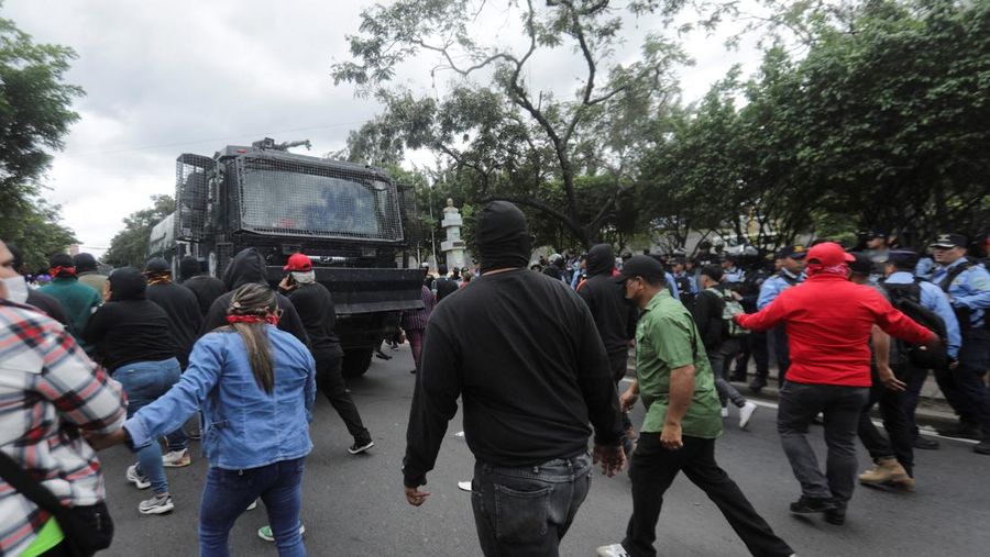 Para pendukung calon presiden Salvador Nasralla dari Partai Liberal berunjuk rasa di depan polisi anti huru hara, lebih dari dua minggu setelah pemilihan presiden, karena penghitungan suara masih terhenti di tengah surat suara yang belum dihitung, tuduhan kecurangan, dan kegagalan sistem pemilu, di Tegucigalpa, Honduras, 15 Desember 2025. (REUTERS/Fredy Rodriguez)
