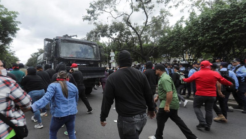 Para pendukung calon presiden Salvador Nasralla dari Partai Liberal berunjuk rasa di depan polisi anti huru hara, lebih dari dua minggu setelah pemilihan presiden, karena penghitungan suara masih terhenti di tengah surat suara yang belum dihitung, tuduhan kecurangan, dan kegagalan sistem pemilu, di Tegucigalpa, Honduras, 15 Desember 2025. (REUTERS/Fredy Rodriguez)