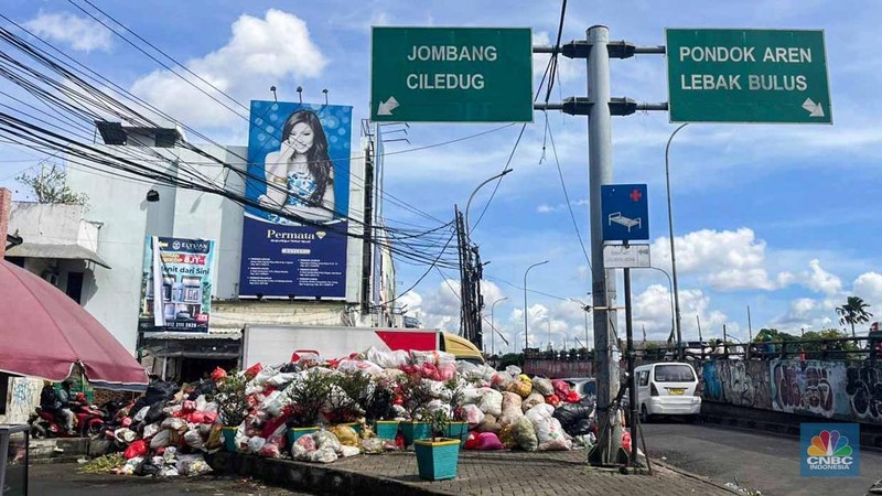 Sejumlah kendaraan melintas di antara tumpukan sampah yang berserakan di beberapa titik Pasar Ciputat, Kebayoran Lama, Selasa (16/12/2025). (CNBC Indonesia/Romys Binekasri)