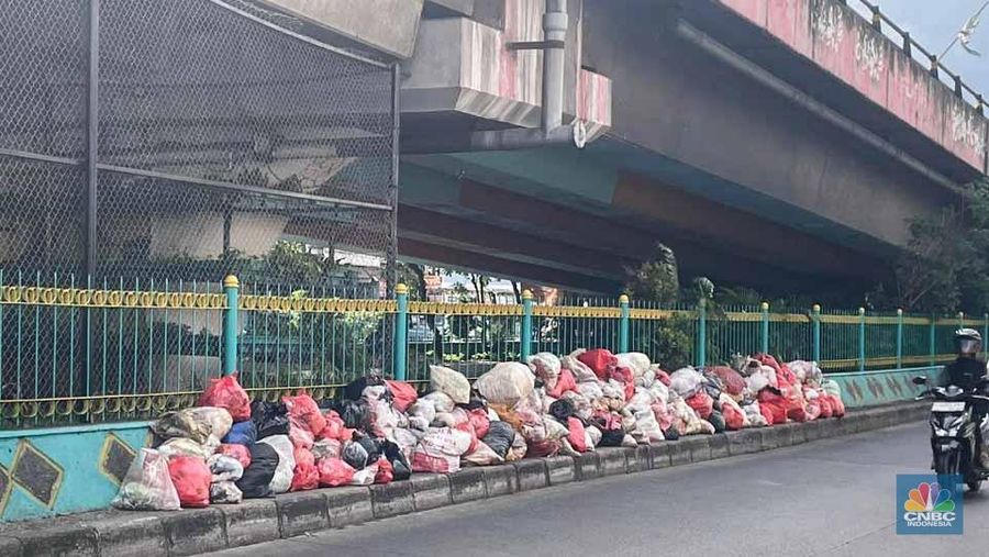 Sejumlah kendaraan melintas di antara tumpukan sampah yang berserakan di beberapa titik Pasar Ciputat, Kebayoran Lama, Selasa (16/12/2025). (CNBC Indonesia/Romys Binekasri)