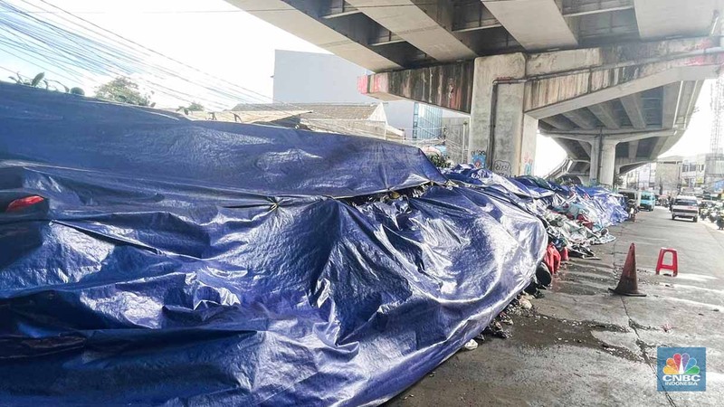 Sejumlah kendaraan melintas di antara tumpukan sampah yang berserakan di beberapa titik Pasar Ciputat, Kebayoran Lama, Selasa (16/12/2025). (CNBC Indonesia/Romys Binekasri)