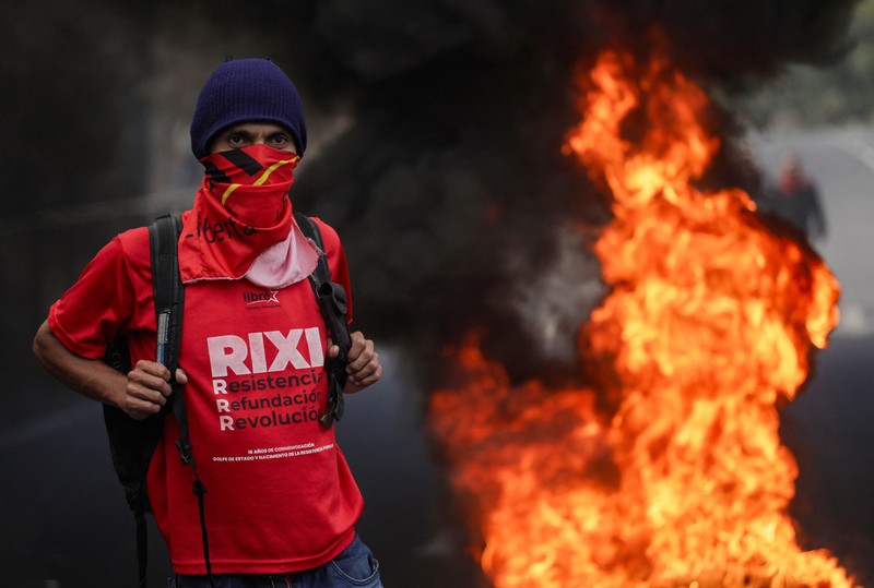 Para pendukung calon presiden Salvador Nasralla dari Partai Liberal berunjuk rasa di depan polisi anti huru hara, lebih dari dua minggu setelah pemilihan presiden, karena penghitungan suara masih terhenti di tengah surat suara yang belum dihitung, tuduhan kecurangan, dan kegagalan sistem pemilu, di Tegucigalpa, Honduras, 15 Desember 2025. (REUTERS/Fredy Rodriguez)