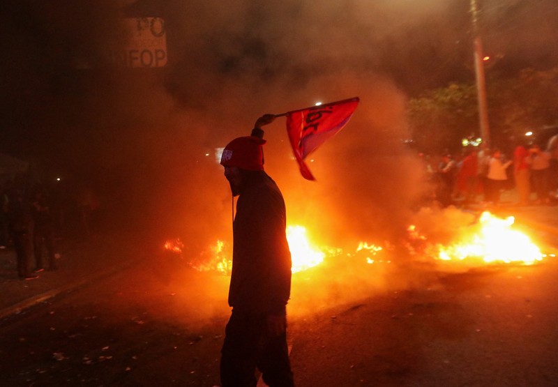 Para pendukung calon presiden Salvador Nasralla dari Partai Liberal berunjuk rasa di depan polisi anti huru hara, lebih dari dua minggu setelah pemilihan presiden, karena penghitungan suara masih terhenti di tengah surat suara yang belum dihitung, tuduhan kecurangan, dan kegagalan sistem pemilu, di Tegucigalpa, Honduras, 15 Desember 2025. (REUTERS/Fredy Rodriguez)