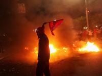 Seorang demonstran ikut serta dalam protes, lebih dari dua minggu setelah pemilihan presiden, karena penghitungan suara masih tertunda di tengah surat suara yang belum dihitung, tuduhan kecurangan, dan kegagalan sistem pemilu, di Tegucigalpa, Hondura