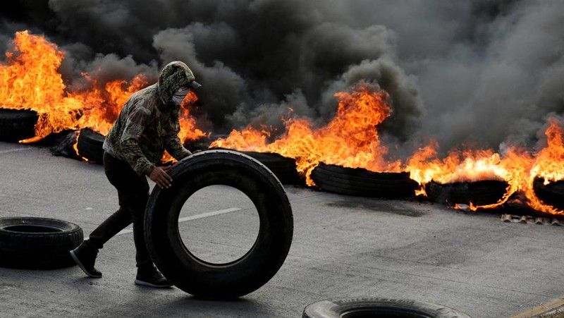 Para pendukung calon presiden Salvador Nasralla dari Partai Liberal berunjuk rasa di depan polisi anti huru hara, lebih dari dua minggu setelah pemilihan presiden, karena penghitungan suara masih terhenti di tengah surat suara yang belum dihitung, tuduhan kecurangan, dan kegagalan sistem pemilu, di Tegucigalpa, Honduras, 15 Desember 2025. (REUTERS/Fredy Rodriguez)
