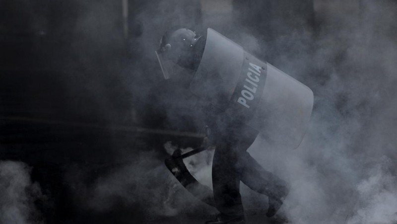 Para pendukung calon presiden Salvador Nasralla dari Partai Liberal berunjuk rasa di depan polisi anti huru hara, lebih dari dua minggu setelah pemilihan presiden, karena penghitungan suara masih terhenti di tengah surat suara yang belum dihitung, tuduhan kecurangan, dan kegagalan sistem pemilu, di Tegucigalpa, Honduras, 15 Desember 2025. (REUTERS/Fredy Rodriguez)