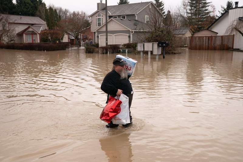 Pemandangan dari drone sebuah lingkungan yang terendam banjir akibat jebolnya penghalang banjir sementara di sepanjang Sungai White, setelah beberapa aliran atmosfer membawa hujan dan banjir ke wilayah Pasifik Barat Laut, di Pacific, Washington, AS, 16 Desember 2025. (REUTERS/David Ryder)