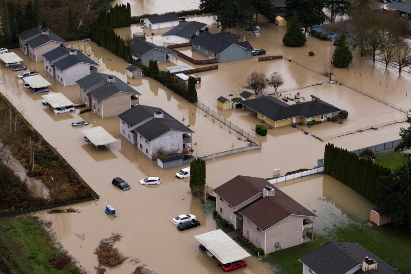 Pemandangan dari drone sebuah lingkungan yang terendam banjir akibat jebolnya penghalang banjir sementara di sepanjang Sungai White, setelah beberapa aliran atmosfer membawa hujan dan banjir ke wilayah Pasifik Barat Laut, di Pacific, Washington, AS, 16 Desember 2025. (REUTERS/David Ryder)