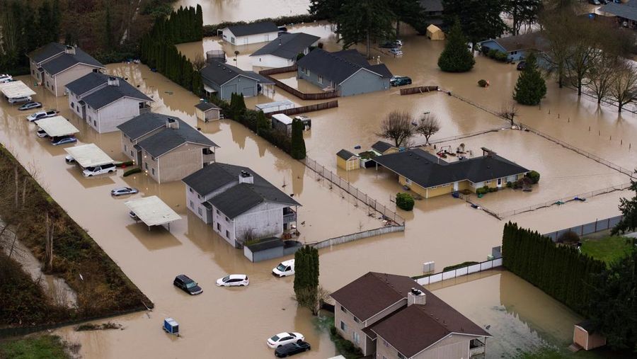 Pemandangan dari drone sebuah lingkungan yang terendam banjir akibat jebolnya penghalang banjir sementara di sepanjang Sungai White, setelah beberapa aliran atmosfer membawa hujan dan banjir ke wilayah Pasifik Barat Laut, di Pacific, Washington, AS, 16 Desember 2025. (REUTERS/David Ryder)