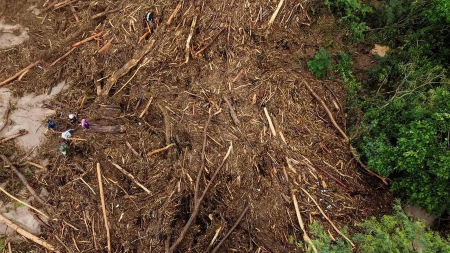 Anggota komunitas dari berbagai desa mencari orang hilang di antara puing-puing kayu setelah banjir yang dipicu oleh luapan sungai di wilayah Santa Cruz timur mengisolasi beberapa komunitas, di El Torno, Bolivia, 16 Desember 2025. (REUTERS/Claudia Morales)