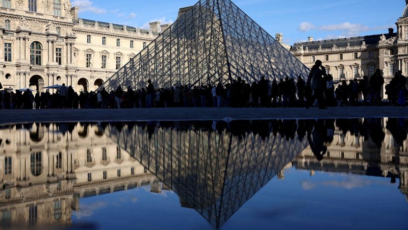 Ratusan turis terpaksa mengantre di luar Museum Louvre di Prancis pada Rabu (17/12/2025) waktu setempat. Jam buka museum tertunda imbas serikat pekerja menggelar pemungutan suara untuk melanjutkan aksi mogok kerja terkait kondisi kerja di museum ikonik tersebut. (REUTERS/Abdul Saboor)