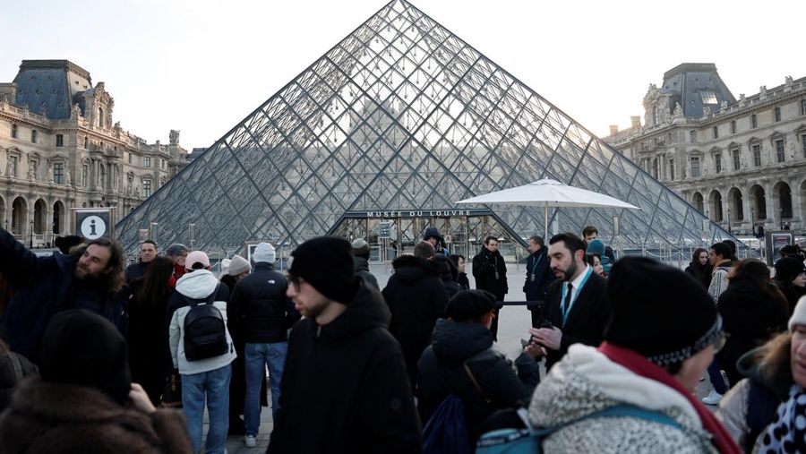 Ratusan turis terpaksa mengantre di luar Museum Louvre di Prancis pada Rabu (17/12/2025) waktu setempat. Jam buka museum tertunda imbas serikat pekerja menggelar pemungutan suara untuk melanjutkan aksi mogok kerja terkait kondisi kerja di museum ikonik tersebut. (REUTERS/Abdul Saboor)