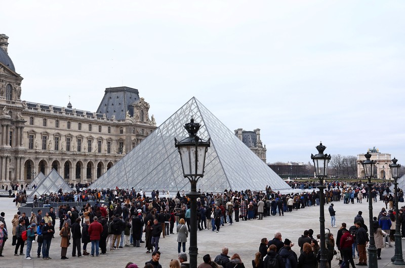 Ratusan turis terpaksa mengantre di luar Museum Louvre di Prancis pada Rabu (17/12/2025) waktu setempat. Jam buka museum tertunda imbas serikat pekerja menggelar pemungutan suara untuk melanjutkan aksi mogok kerja terkait kondisi kerja di museum ikonik tersebut. (REUTERS/Abdul Saboor)