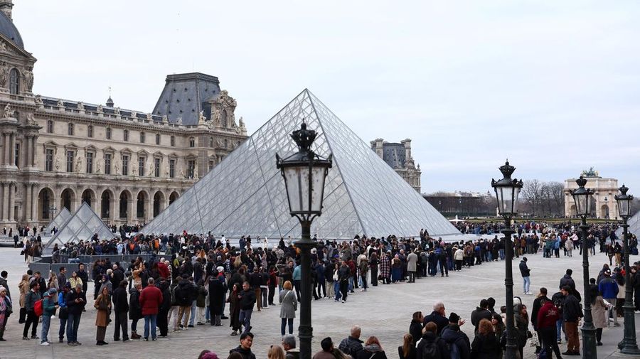 Ratusan turis terpaksa mengantre di luar Museum Louvre di Prancis pada Rabu (17/12/2025) waktu setempat. Jam buka museum tertunda imbas serikat pekerja menggelar pemungutan suara untuk melanjutkan aksi mogok kerja terkait kondisi kerja di museum ikonik tersebut. (REUTERS/Abdul Saboor)