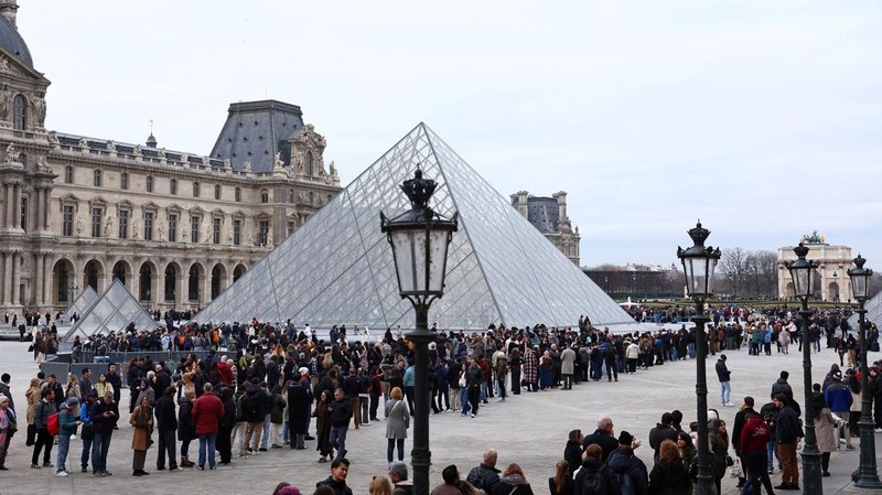 Ratusan turis terpaksa mengantre di luar Museum Louvre di Prancis pada Rabu (17/12/2025) waktu setempat. Jam buka museum tertunda imbas serikat pekerja menggelar pemungutan suara untuk melanjutkan aksi mogok kerja terkait kondisi kerja di museum ikonik tersebut. (REUTERS/Abdul Saboor)