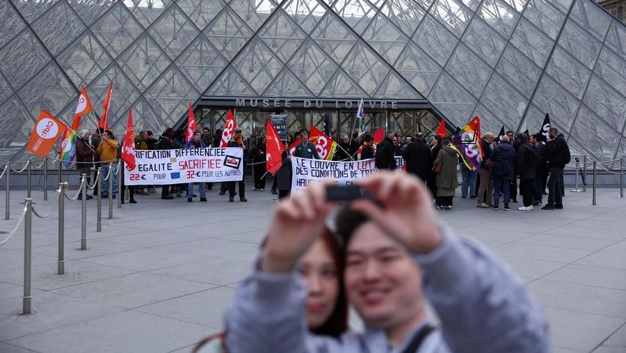 Ratusan turis terpaksa mengantre di luar Museum Louvre di Prancis pada Rabu (17/12/2025) waktu setempat. Jam buka museum tertunda imbas serikat pekerja menggelar pemungutan suara untuk melanjutkan aksi mogok kerja terkait kondisi kerja di museum ikonik tersebut. (REUTERS/Abdul Saboor)