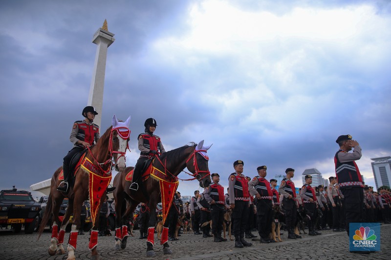 Anggota kepolisian mengikuti Apel Gelar Pasukan-Ops Lilin di kawasan Monumen Nasional (Monas), Jumat (19/12/2025). (CNBC Indonesia/Faisal Rahman)