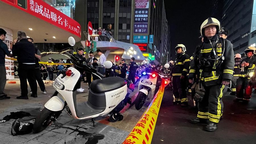Beberapa skuter polisi diparkir di samping sisa-sisa darah di luar toko Eslite Spectrum Nanxi dekat stasiun Zhongshan, sementara pintu masuk gedung dikordon dengan pita kuning penanda TKP, menyusul insiden di mana beberapa orang terluka setelah seseorang melempar bom asap dan menyerang orang-orang yang berada di sekitar lokasi kejadian, menurut pemerintah dan media lokal, di Taipei, Taiwan, 19 Desember 2025. (REUTERS/Ann Wang)