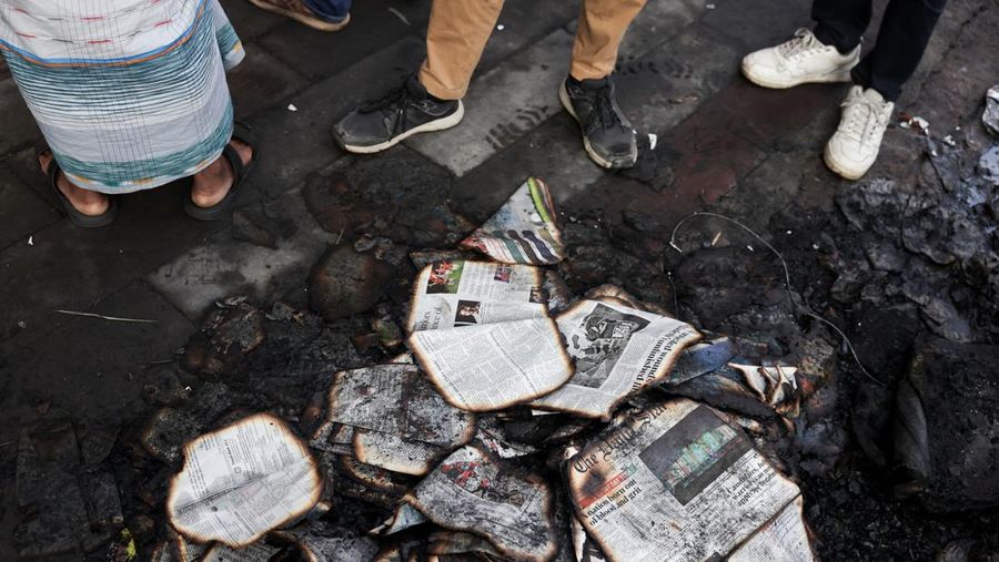Seorang pria berjalan setelah sekelompok orang membakar gedung kantor surat kabar The Daily Star menyusul kematian Sharif Osman Hadi, seorang pemimpin mahasiswa yang sedang menjalani perawatan di Singapura setelah ditembak di kepala, di Dhaka, Bangladesh, 19 Desember 2025. (REUTERS/Abdul Goni)