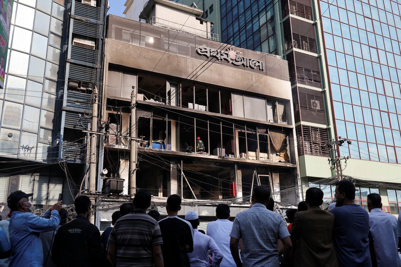 Seorang pria berjalan setelah sekelompok orang membakar gedung kantor surat kabar The Daily Star menyusul kematian Sharif Osman Hadi, seorang pemimpin mahasiswa yang sedang menjalani perawatan di Singapura setelah ditembak di kepala, di Dhaka, Bangladesh, 19 Desember 2025. (REUTERS/Abdul Goni)