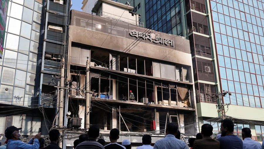 Seorang pria berjalan setelah sekelompok orang membakar gedung kantor surat kabar The Daily Star menyusul kematian Sharif Osman Hadi, seorang pemimpin mahasiswa yang sedang menjalani perawatan di Singapura setelah ditembak di kepala, di Dhaka, Bangladesh, 19 Desember 2025. (REUTERS/Abdul Goni)