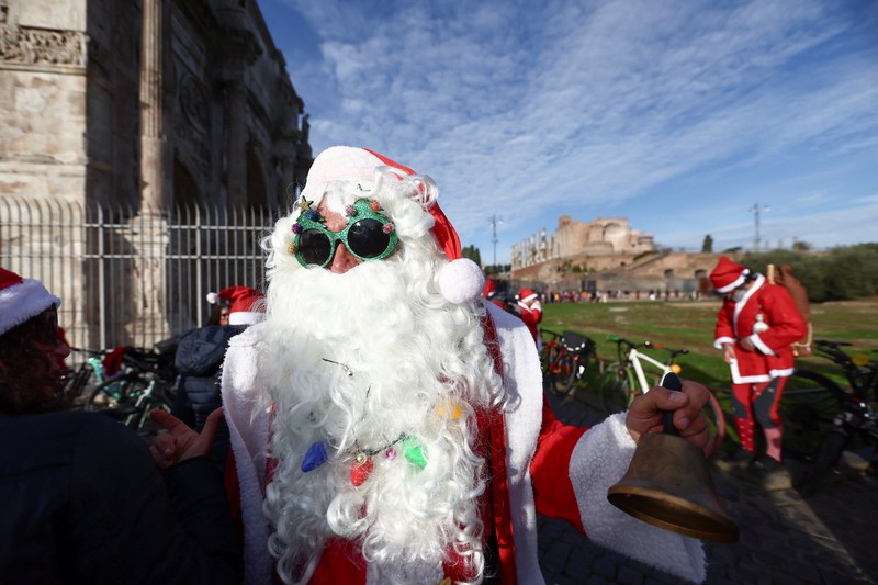 Sejumlah warga berdandan menjadi sinterklas dan bersepeda keliling Roma untuk menggalang dana untuk kegiatan amal, Minggu (21/12/2025). (REUTERS/Yara Nardi)