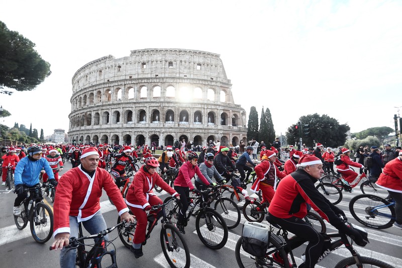 Sejumlah warga berdandan menjadi sinterklas dan bersepeda keliling Roma untuk menggalang dana untuk kegiatan amal, Minggu (21/12/2025). (REUTERS/Yara Nardi)