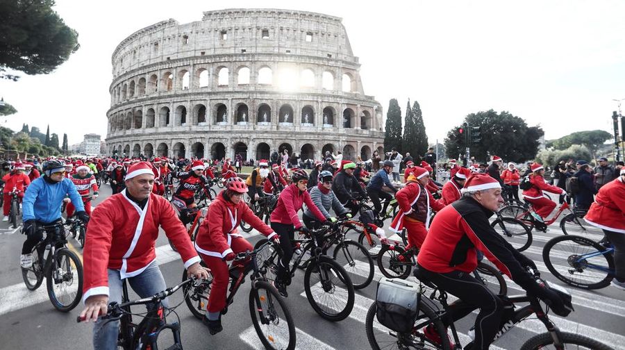Sejumlah warga berdandan menjadi sinterklas dan bersepeda keliling Roma untuk menggalang dana untuk kegiatan amal, Minggu (21/12/2025). (REUTERS/Yara Nardi)