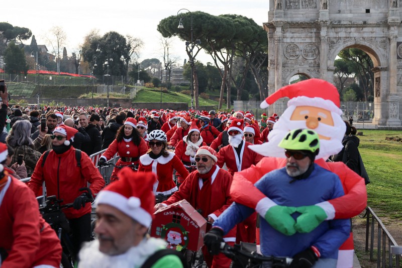 Sejumlah warga berdandan menjadi sinterklas dan bersepeda keliling Roma untuk menggalang dana untuk kegiatan amal, Minggu (21/12/2025). (REUTERS/Yara Nardi)