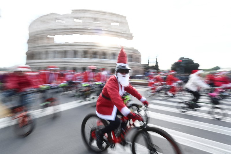 Sejumlah warga berdandan menjadi sinterklas dan bersepeda keliling Roma untuk menggalang dana untuk kegiatan amal, Minggu (21/12/2025). (REUTERS/Yara Nardi)