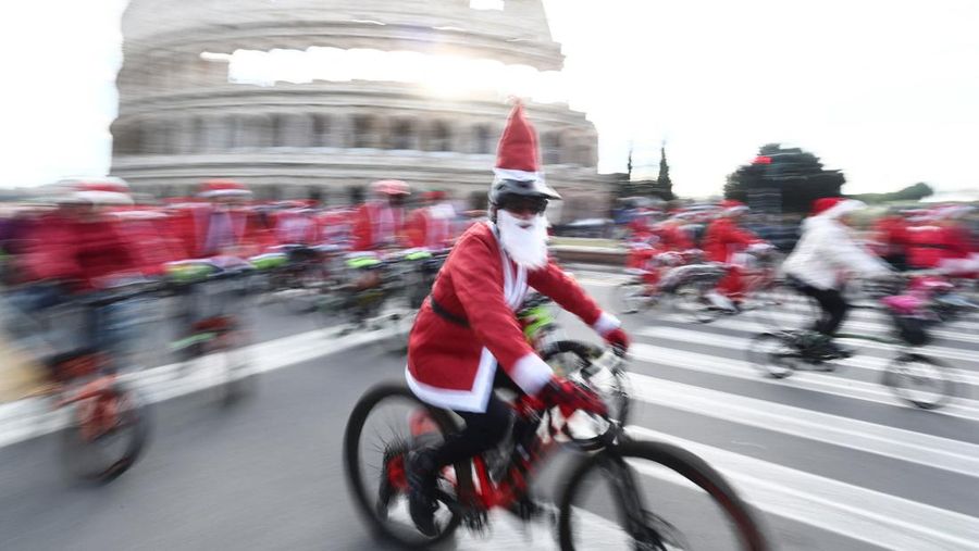 Sejumlah warga berdandan menjadi sinterklas dan bersepeda keliling Roma untuk menggalang dana untuk kegiatan amal, Minggu (21/12/2025). (REUTERS/Yara Nardi)