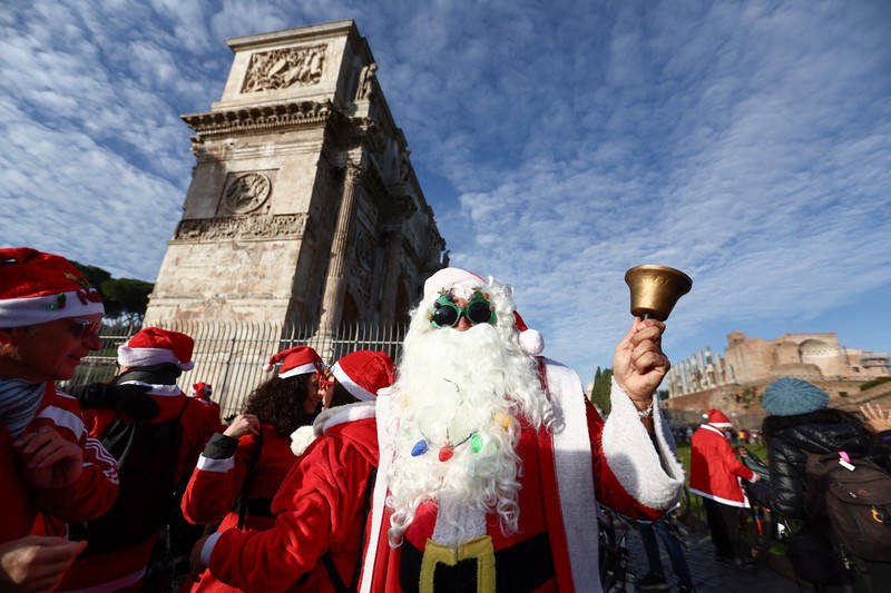 Sejumlah warga berdandan menjadi sinterklas dan bersepeda keliling Roma untuk menggalang dana untuk kegiatan amal, Minggu (21/12/2025). (REUTERS/Yara Nardi)