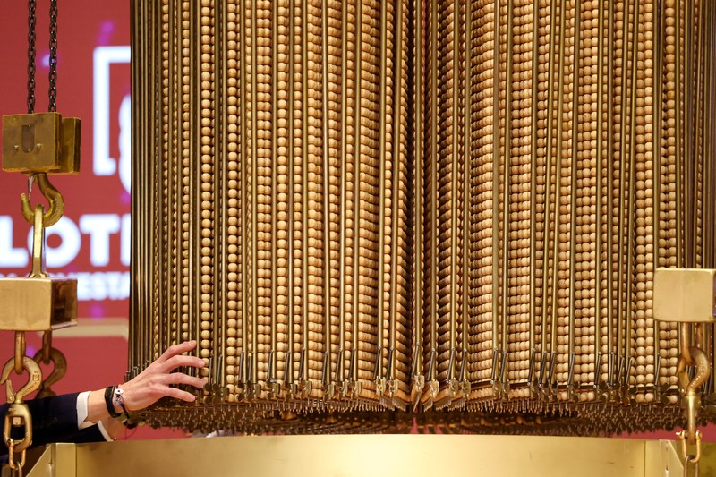 Workers operate the lottery machine, on the day of Spain's Christmas lottery