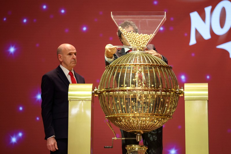 Workers operate the lottery machine, on the day of Spain's Christmas lottery