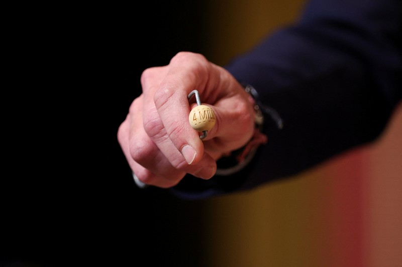 Workers operate the lottery machine, on the day of Spain's Christmas lottery