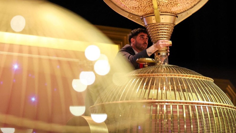 Workers operate the lottery machine, on the day of Spain's Christmas lottery 