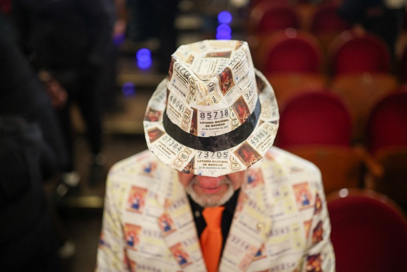 Workers operate the lottery machine, on the day of Spain's Christmas lottery