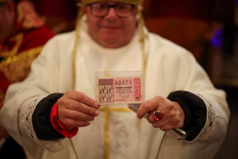 Workers operate the lottery machine, on the day of Spain's Christmas lottery