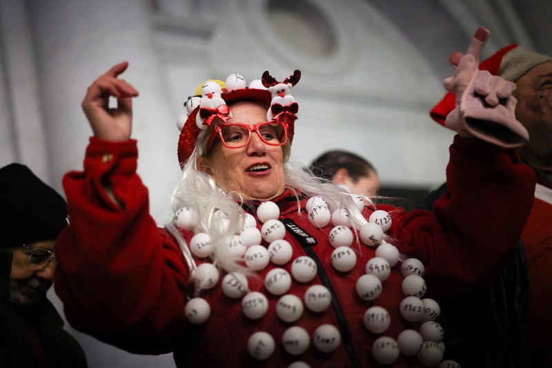 Workers operate the lottery machine, on the day of Spain's Christmas lottery