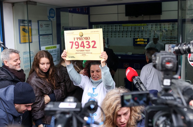 Workers operate the lottery machine, on the day of Spain's Christmas lottery
