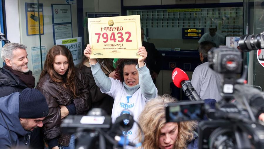Workers operate the lottery machine, on the day of Spain's Christmas lottery 