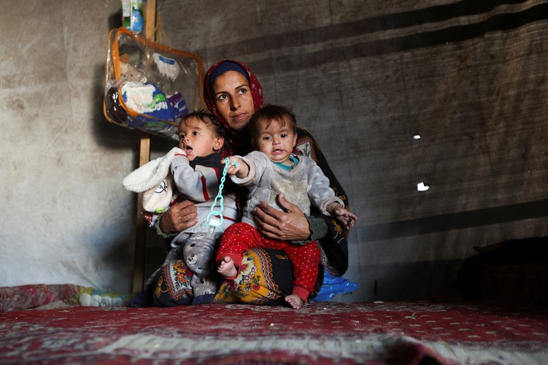 Palestinians pray near the body of baby Saeed Abdeen, who according to the medics died due to cold weather, in Khan Younis, southern Gaza Strip, December 18, 2025. REUTERS/Ramadan Abed