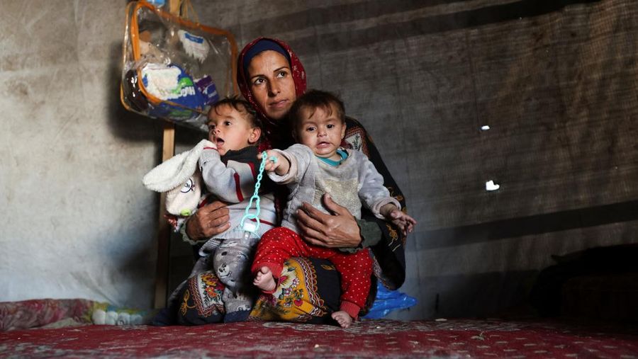Palestinians pray near the body of baby Saeed Abdeen, who according to the medics died due to cold weather, in Khan Younis, southern Gaza Strip, December 18, 2025. REUTERS/Ramadan Abed