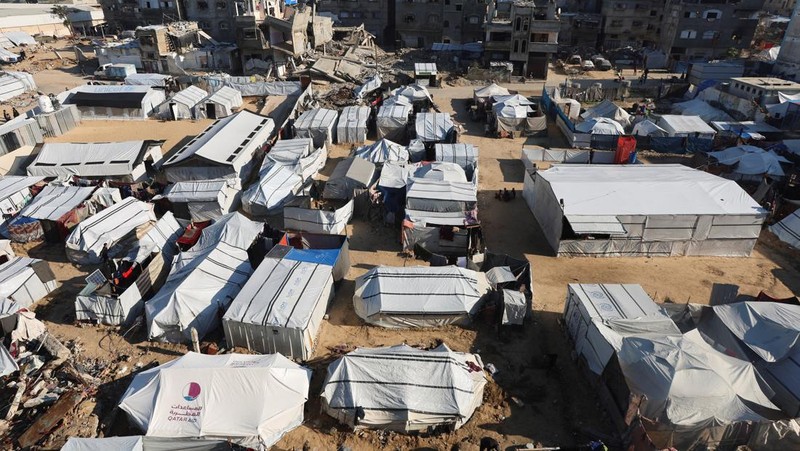 Palestinians pray near the body of baby Saeed Abdeen, who according to the medics died due to cold weather, in Khan Younis, southern Gaza Strip, December 18, 2025. REUTERS/Ramadan Abed